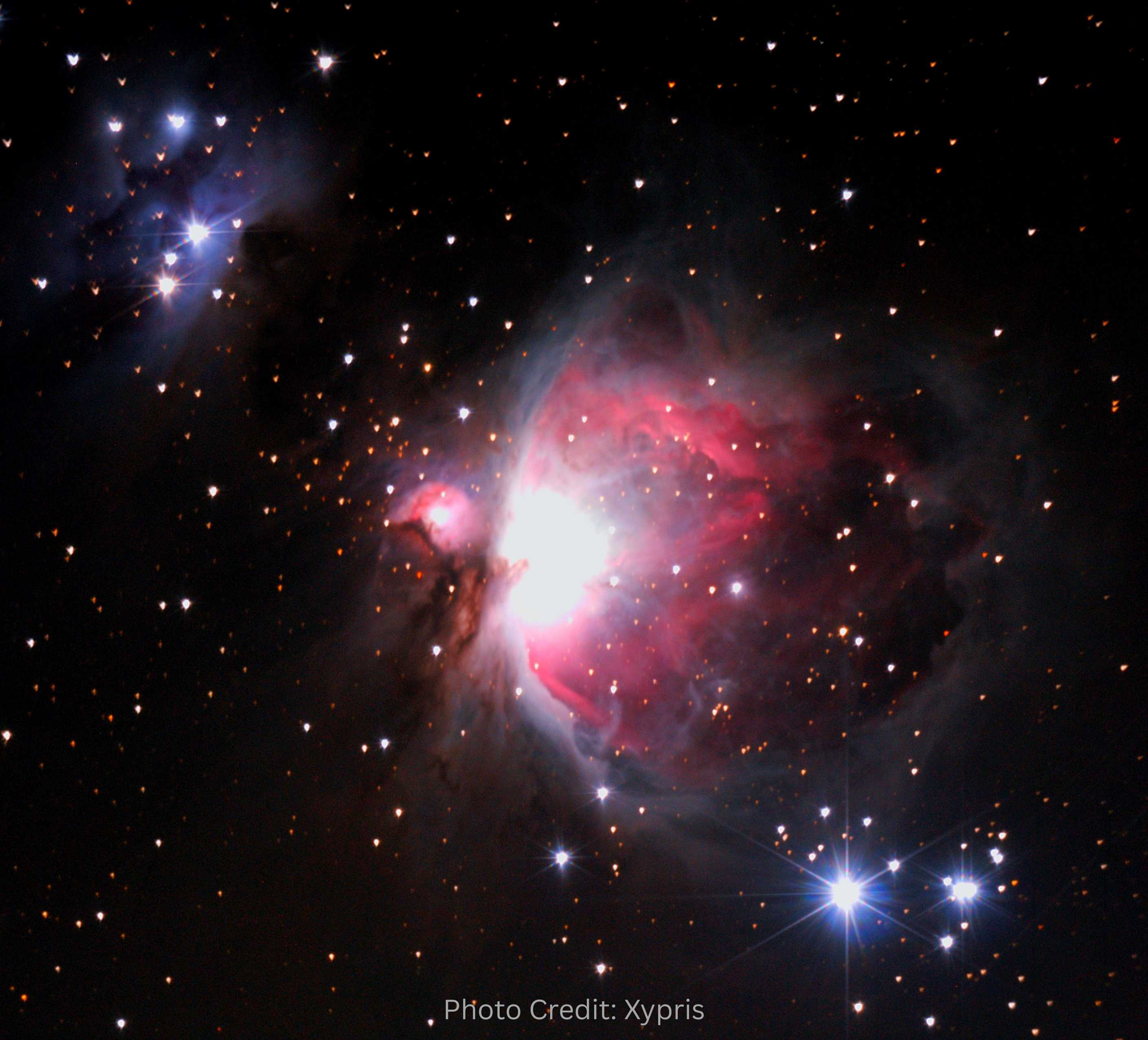 Starry night sky with a prominent nebula and stars, credit to Xypris.