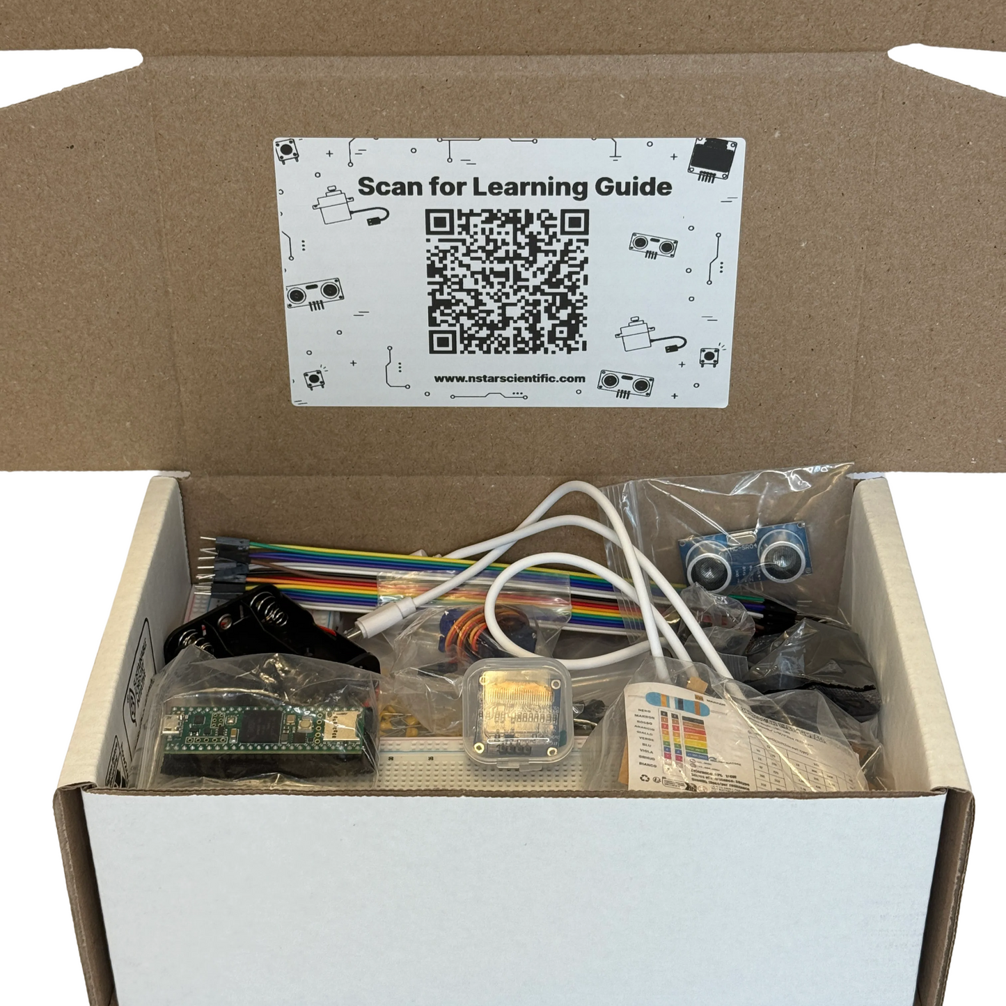 An electronics kit opened in a cardboard box, showing various components including a breadboard, wires, a microcontroller, a sensor module, and a blue motor, with a sticker reading 'Scan for Learning Guide' on the inside lid.